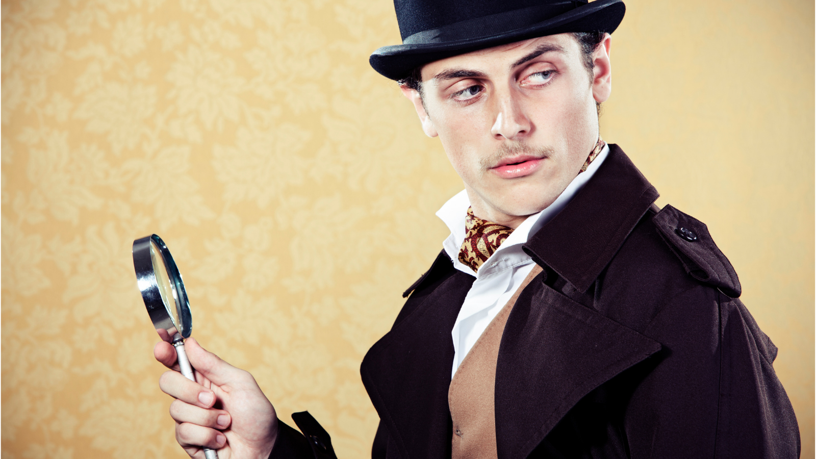 Fellow in a bowler hat with a magnifying glass in hand.
