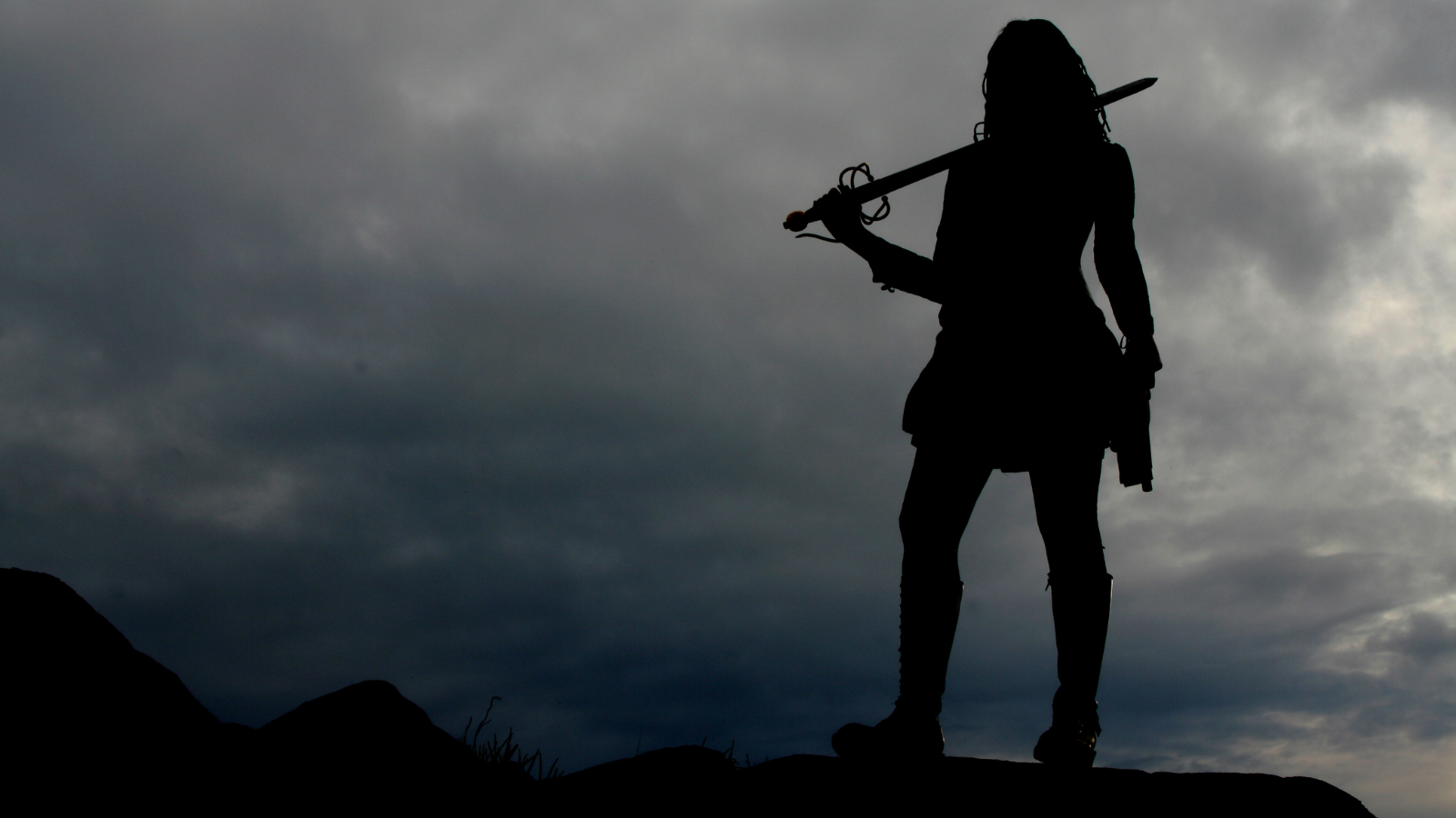 The silhouette of a woman holding a sword.