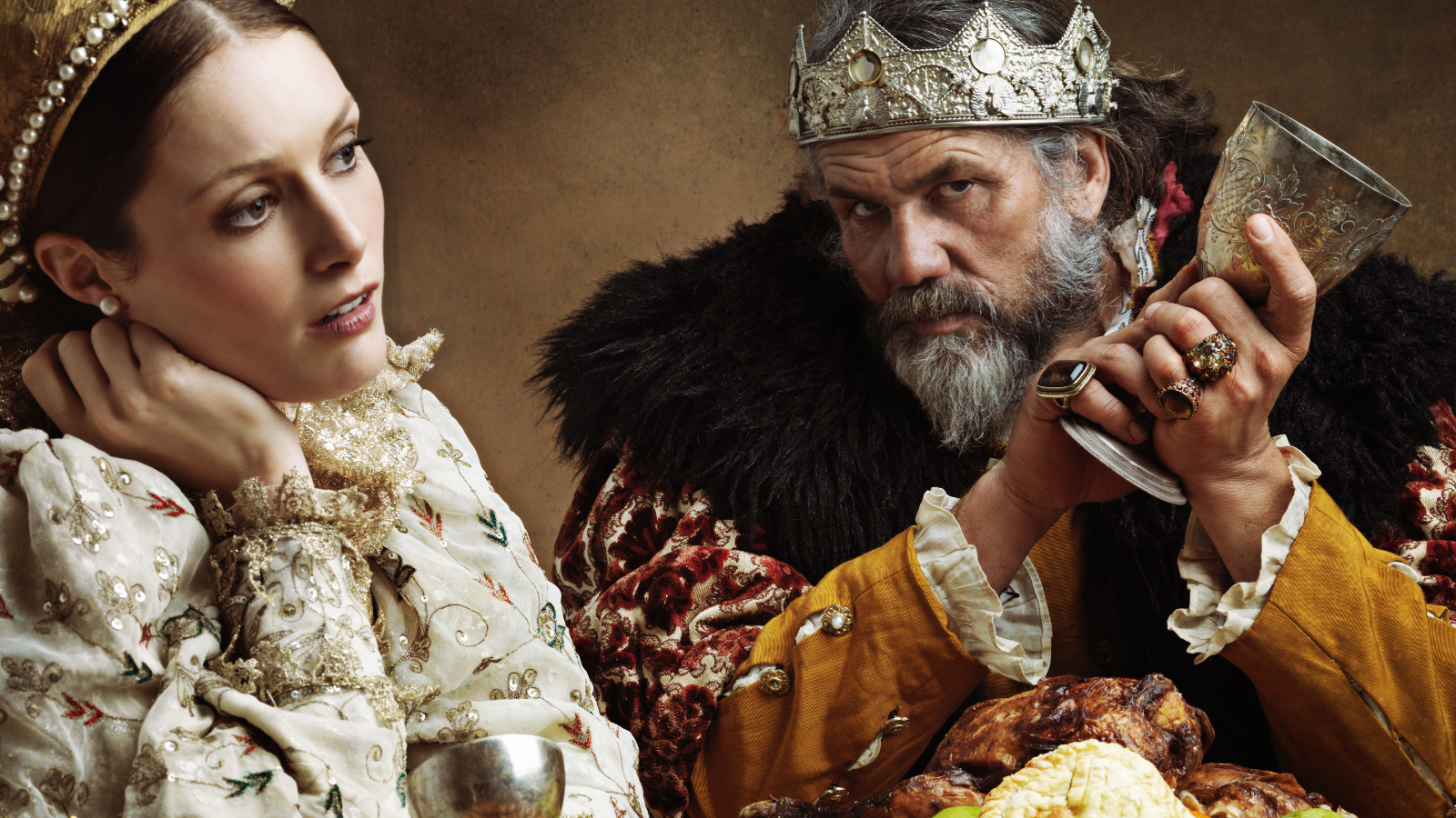 Bored-looking queen and suspicious king at dinner.