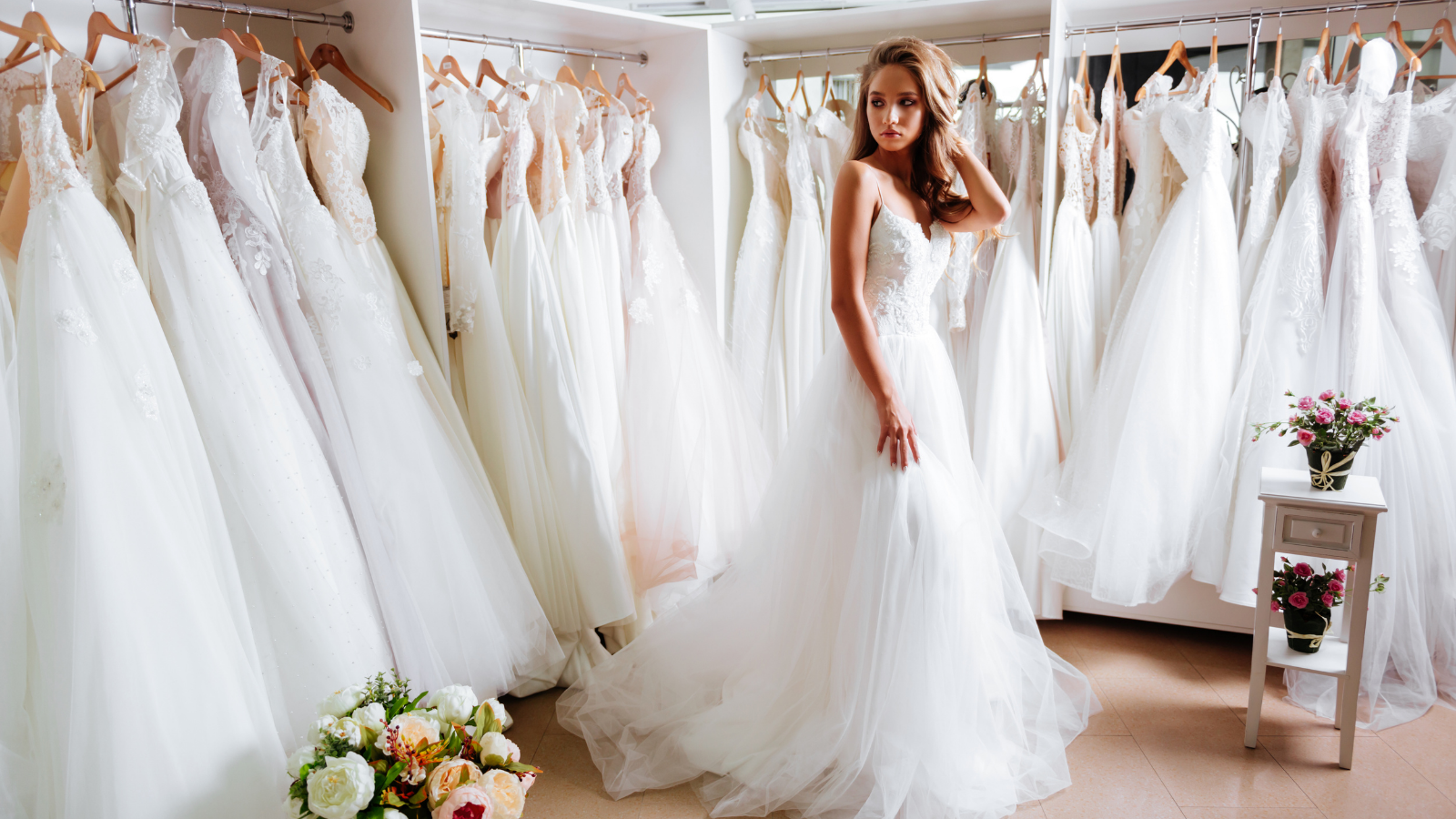 Woman trying on a bridal gown with an airy chiffon skirt.